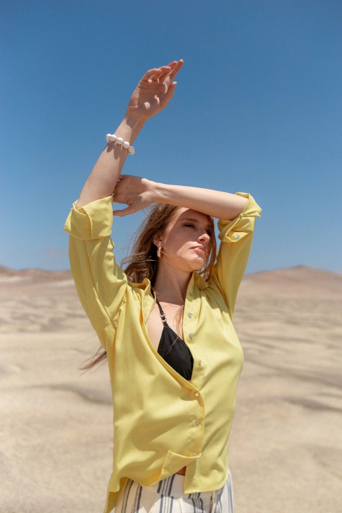 Modelo vistiendo blusa amarilla - The Showroom Perú - imagen decorativa en página Política de Cambios y Devoluciones